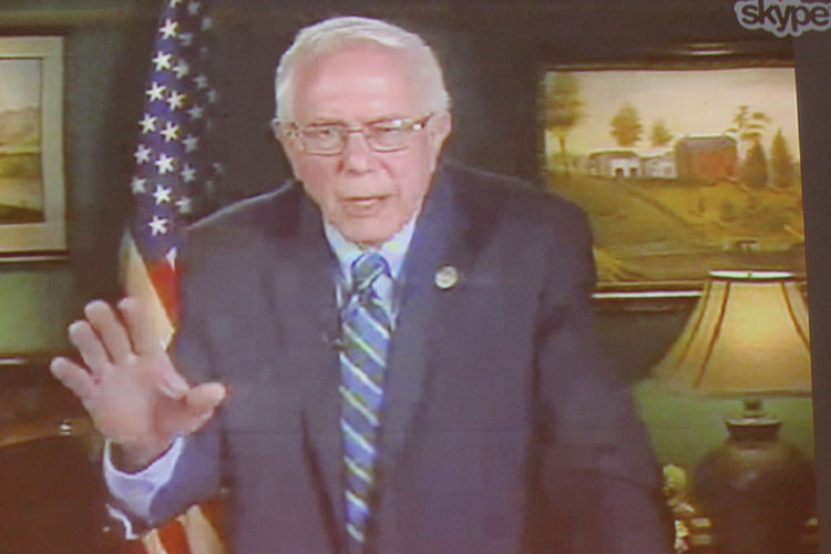 Senator Bernie Sanders addressing audience in Bentley via Skype