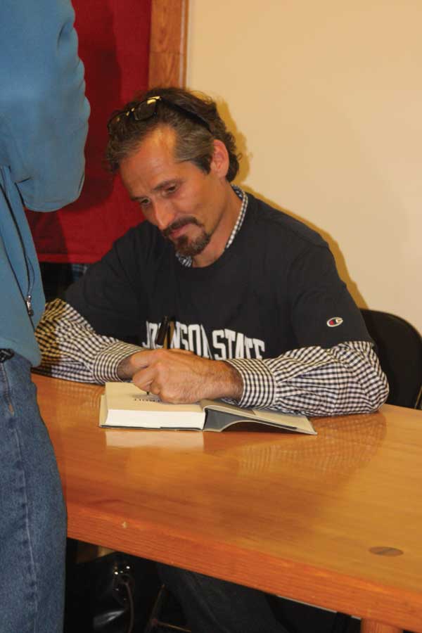 Charlie LeDuff signs a copy of his book "Detroit: An American Autopsy."