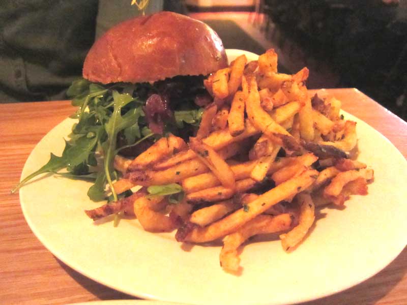 The Mule's “Works for Me,” a burger topped with pickled onions, arugula, and aioli priced at $18.