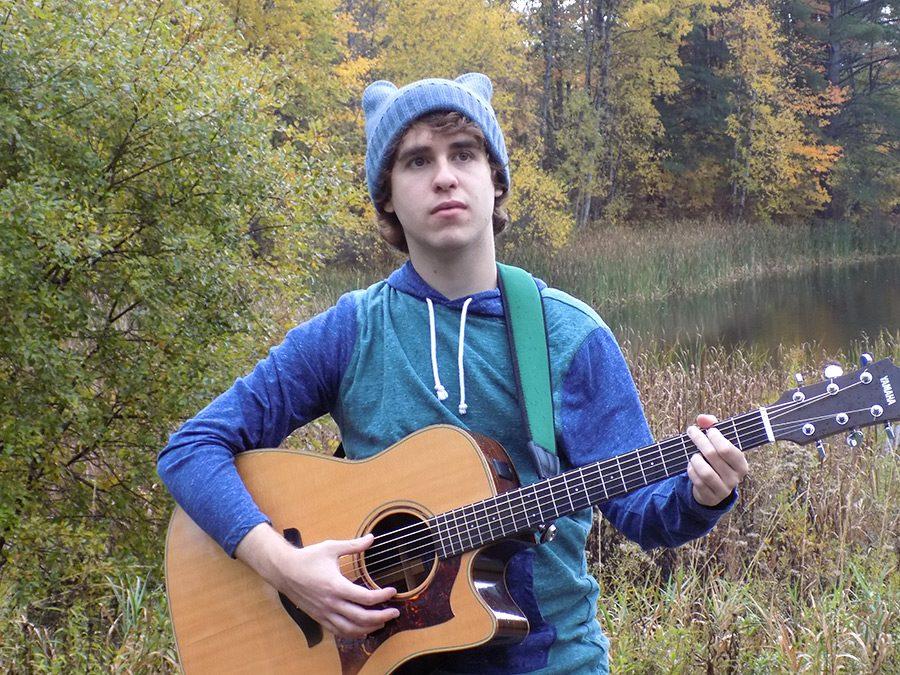 Chad Tarves pensively strums his guitar