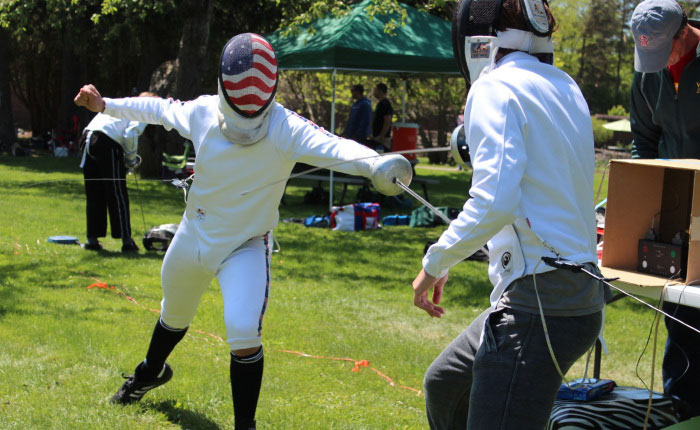 Two fencers cross swords during a bout