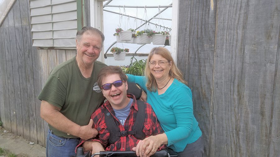 Joe, Jay and Anne Tisbert pose in front of one of their greehouses