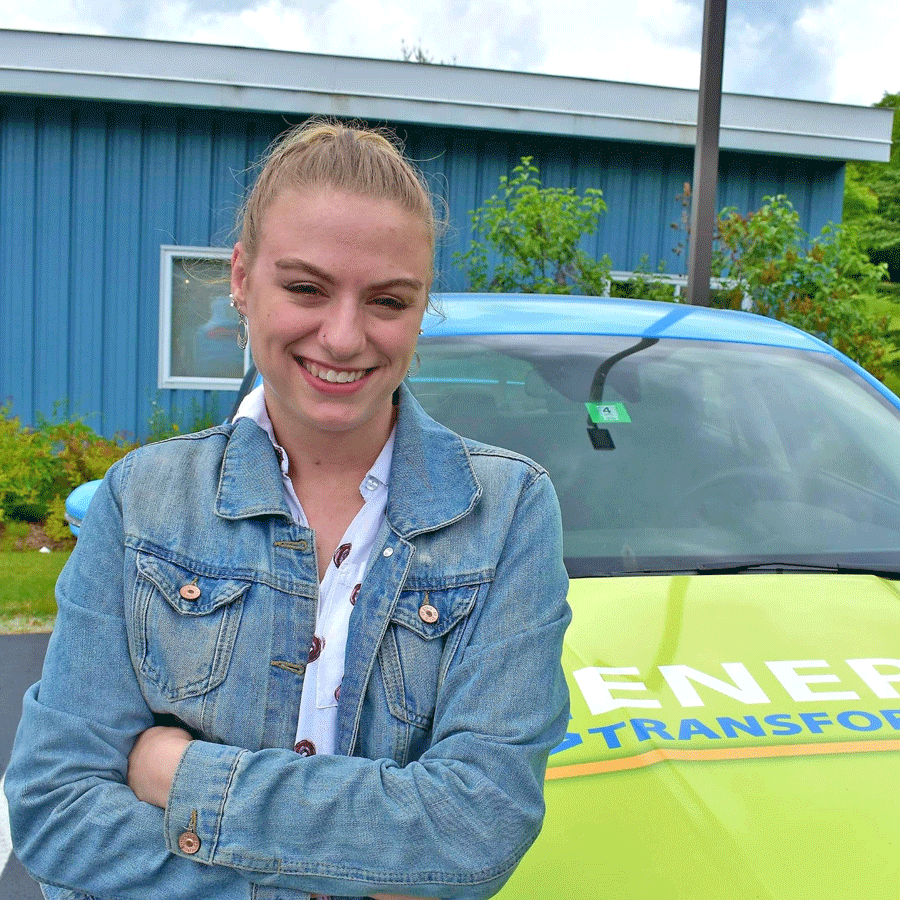 Adriana Eldred leans on one of VECs EVs.