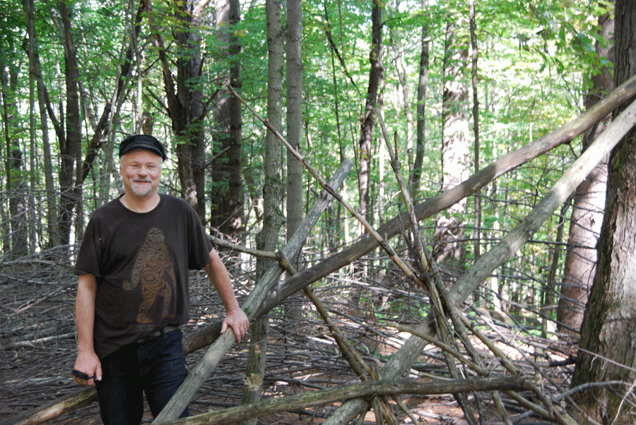 Christopher Noel standing by a Sasquatch structure