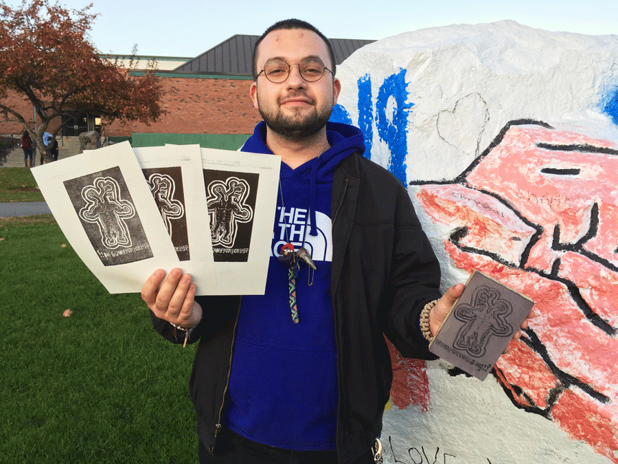 Ian holds his linoleum prints 