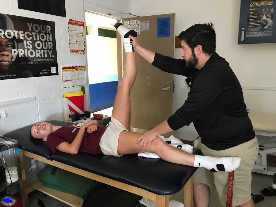 Ben Michon in the athletic trainer's office with student athlete Morgan Grace