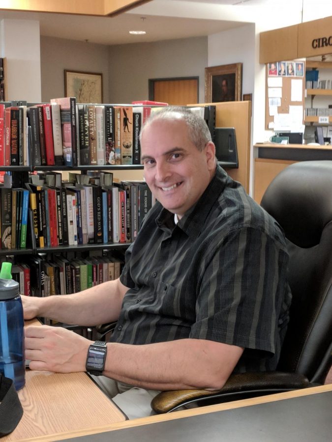 Michael Dente sits at his office chair in Willey Library in early September 2018